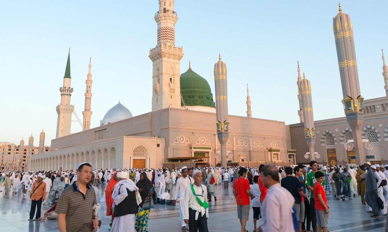 The hajj 2013 at prophet Muhammad Mosque Medina, Saudi Arabia - September 23, 2013: Pilgrims walk outside Masjid Nabawi after morning prayer Sep 23, 2013 in Medina, KSA. Underneath the green dome where Prophet Muhammad is laid to rest.
